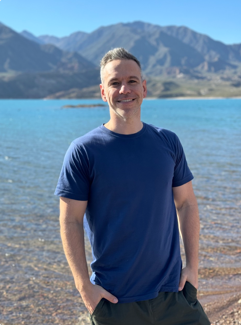 Dani Presman junto a un lago y montañas